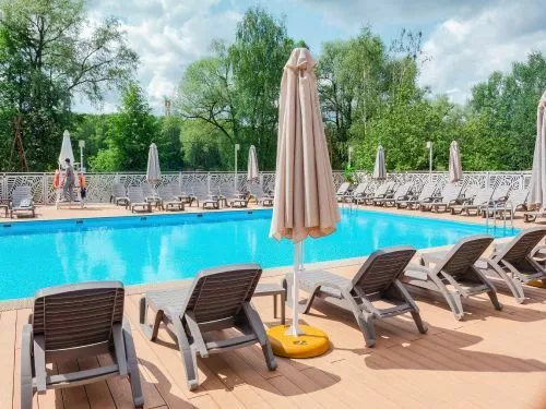 Custom commercial pool with lounge chairs and umbrellas in New Caney, TX.